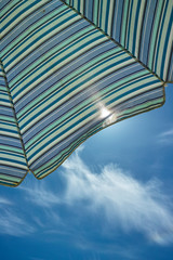 Sun umbrella for sun protention of skin and head on sunny beach in summer