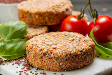 Fototapeta na wymiar Tasty vegetarian burgers made from healthy quinoa, basil, tomatoes and mozzarella cheese