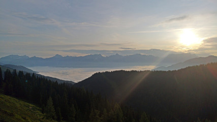 beautiful morning and sunrise in the mountains with view to the alps and fog in the valley