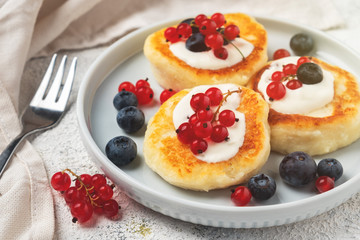 Cottage cheese pancakes with red currant and blueberry, close-up.