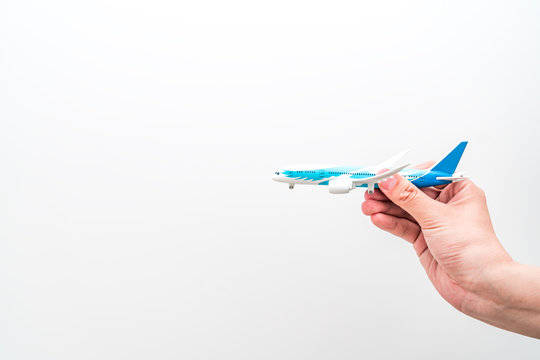 Flying concept picture of hand held aircraft model under white background