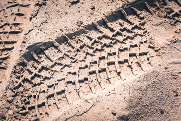 Long tracks from the wheels of passenger car in the sand.