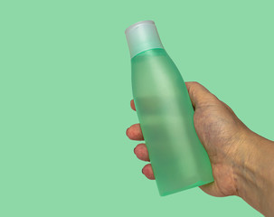 plastic matte bottle with cosmetic tonic on turquoise background