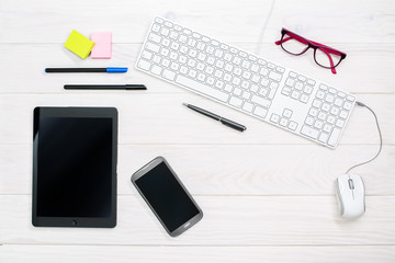 Workspace with keyboard, smartphone, tablet and office supplies on white color background. Top view. Flat lay style. Mock up