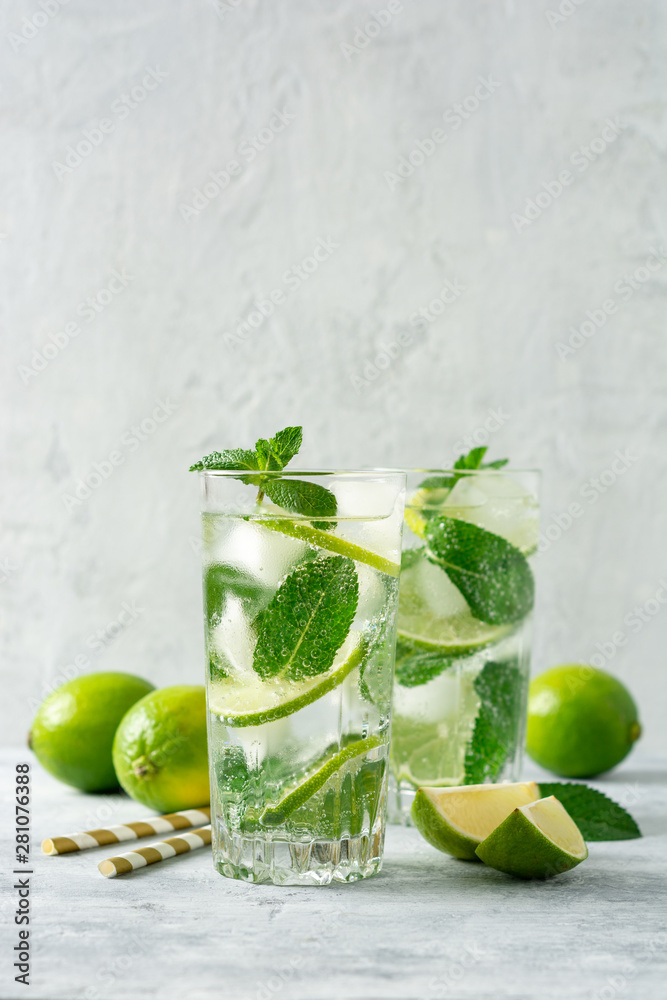 Wall mural fresh mojito cocktail with lime and mint in glass on concrete background. cold refreshing drink. sel