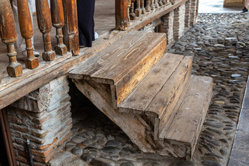 Wooden stairs and railings, cobblestone pavement