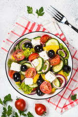 Greek salad in black plate on the table.