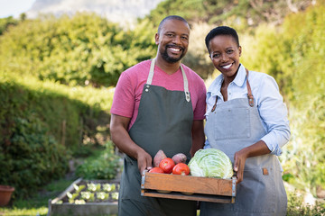 African farmer couple holding vegetable crate