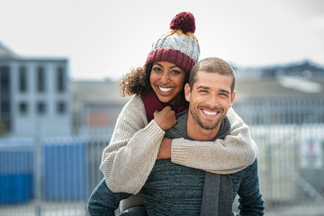 Couple enjoying piggyback ride in winter