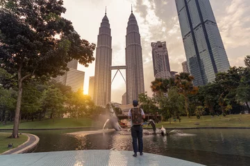 Foto op Plexiglas Een man backpacker is op reis en bezienswaardigheden Landmark twin tower van Kuala Lumpur, Maleisië. © newroadboy