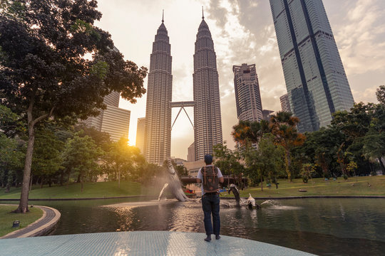 A man backpacker is traveling and sightseeing Landmark twin tower of Kuala Lumpur, Malaysia.