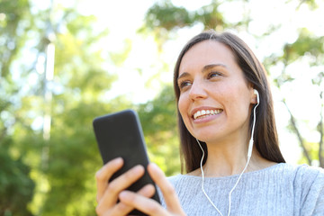 Adult woman listening to music in a park