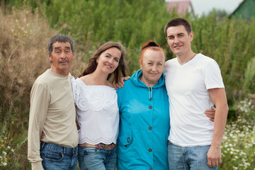 Obraz premium Portrait of adult children with parents on the background of nature