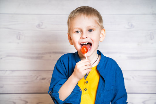 Cute little boy with lollipop. Happy boy eating candy
