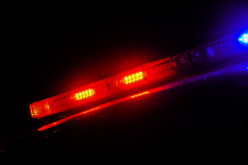 Strobelight bar on top of police car flashing red and blue.