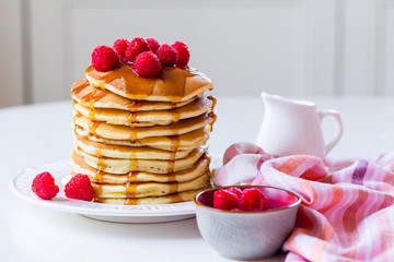 Homemade pancakes with maple syrup and  raspberries