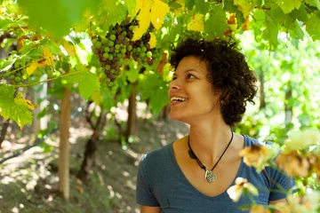 Fotobehang Junge Frau in den Weinbergen, lachend an einer Weintraube © Metzger