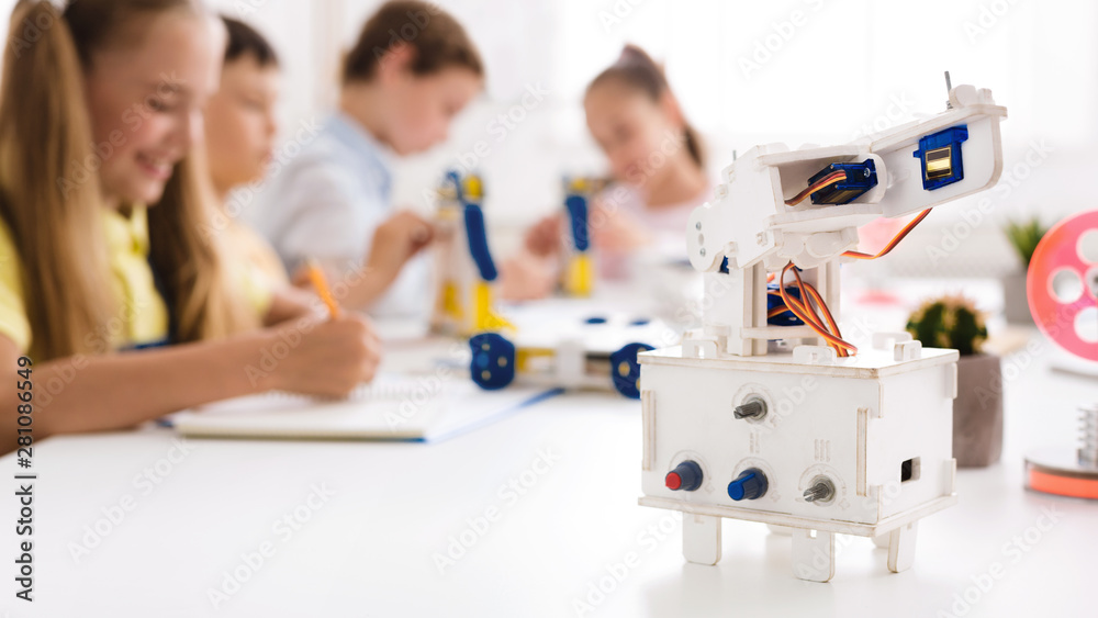 Wall mural Children studying in class with robot at foreground