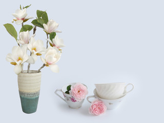 Blooming magnolia fkiwer vase wuth coffee cup.