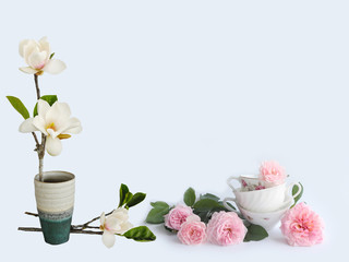 Blooming magnolia fkiwer vase wuth coffee cup.