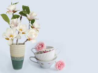 Obraz na płótnie Canvas Blooming magnolia fkiwer vase wuth coffee cup.