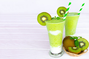 Kiwi yogurt juice healthy smoothies green beverage taste delicious drink summer have proten colorful in the glass and fruit kiwi  on white wood background.