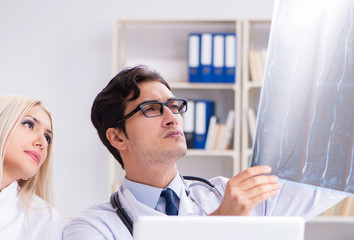 Two doctors examining x-ray images of patient for diagnosis