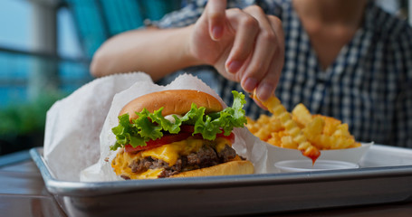 Woman enjoy burger and french fries