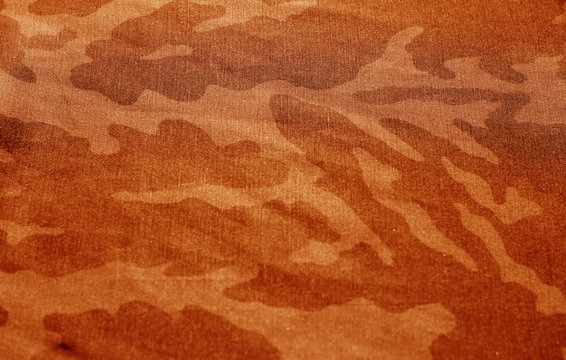 Dirty camouflage cloth with blur effect in orange tone.