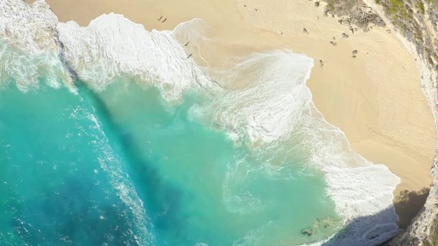Top Down Zoom in Spinning Drone Shot of Big Waves Kelingking Beach at Nusa Penida, Bali - Indonesia