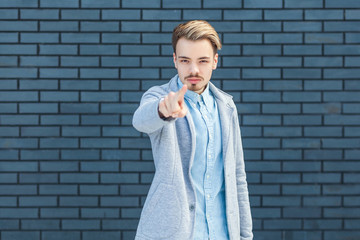 Hey you. Portrait of serious or anger handsome young blonde man in casual style standing, pointing...