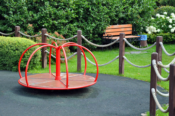 Playground for children in the park among the green trees.