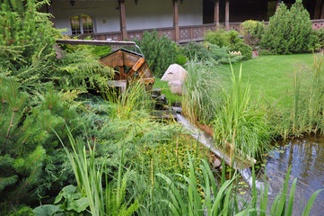 Driving mill wheel with falling water in the garden.