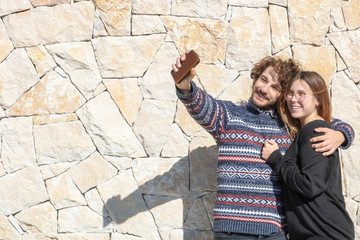 Obraz na płótnie Canvas Jeune couple heureux et souriant prenant un selfie sur leur smartphone durant leur vacances