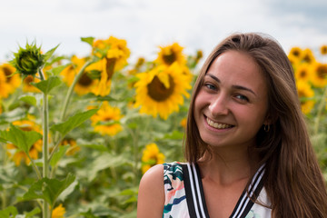 beautiful sweet sexy girl in a white dress walking on a field of sunflowers , smiling a beautiful smile,cheerful girl,style, lifestyle