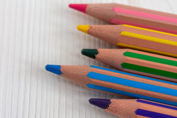 Top view of several colored pencils, with bokeh effect in the background with copy space