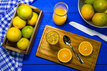Copo Americano com Suco de laranja sobre a mesa de madeira azul.