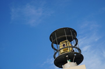 Geodetic total station theodolite in work on sky backround. It is a geodetic tool for measuring...