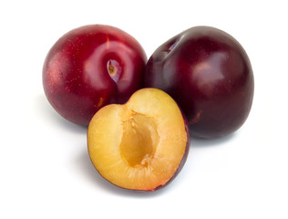 Fototapeta na wymiar Three red and purple plums isolated on white background