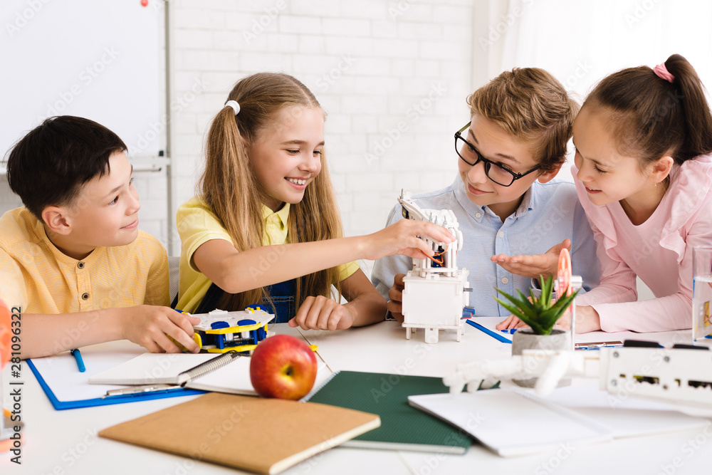 Poster Happy children creating robots at class together