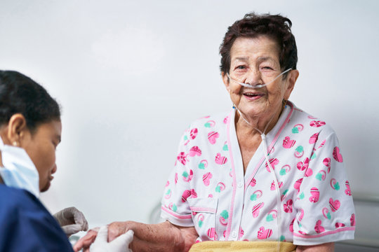 Nurse examining smiling senior woman in hospital