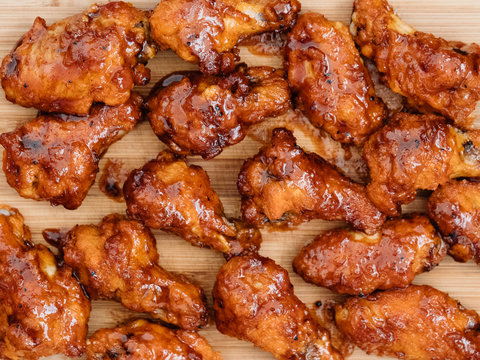 Crispy barbecue chicken wings covered in a sweet and tangy bbq sauce and served at a cookout.