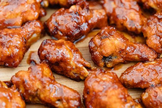 Crispy barbecue chicken wings covered in a sweet and tangy bbq sauce and served at a cookout.