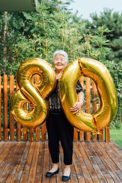 Woman Holding Birthday Balloons