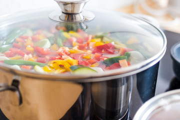 Fresh colorful vegetables in a saucepan. A healthy soup with sweet potatoes, beans, peppers,...