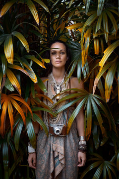Portrait of young woman standing between plants