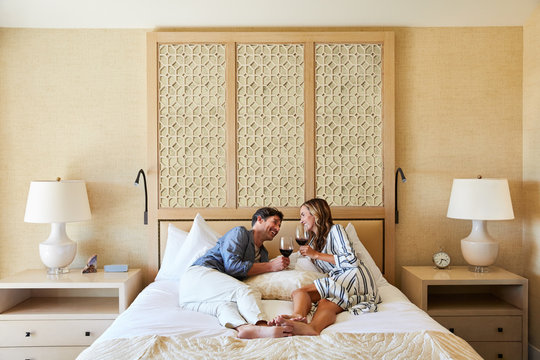 Mature couple enjoying wine in room at resort