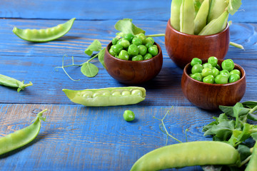 Fresh green peas on the blue wooden table