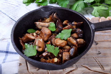 Roasted forest mushrooms topped with fresh parsley in a cast iron pan