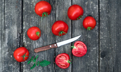 .tomatoes and a knife on a wooden background